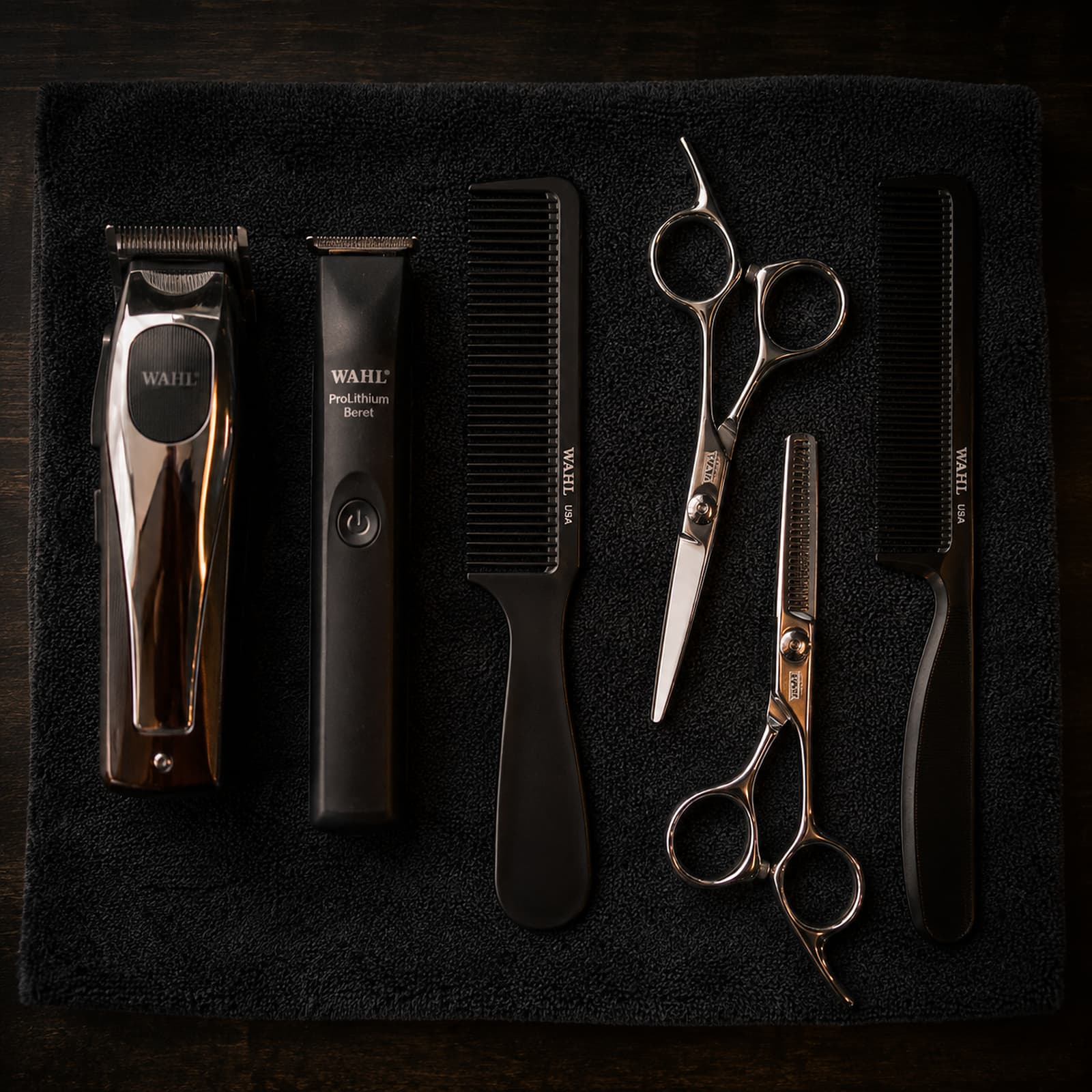 Chrome clippers, combs and shears laid out on a folded towel