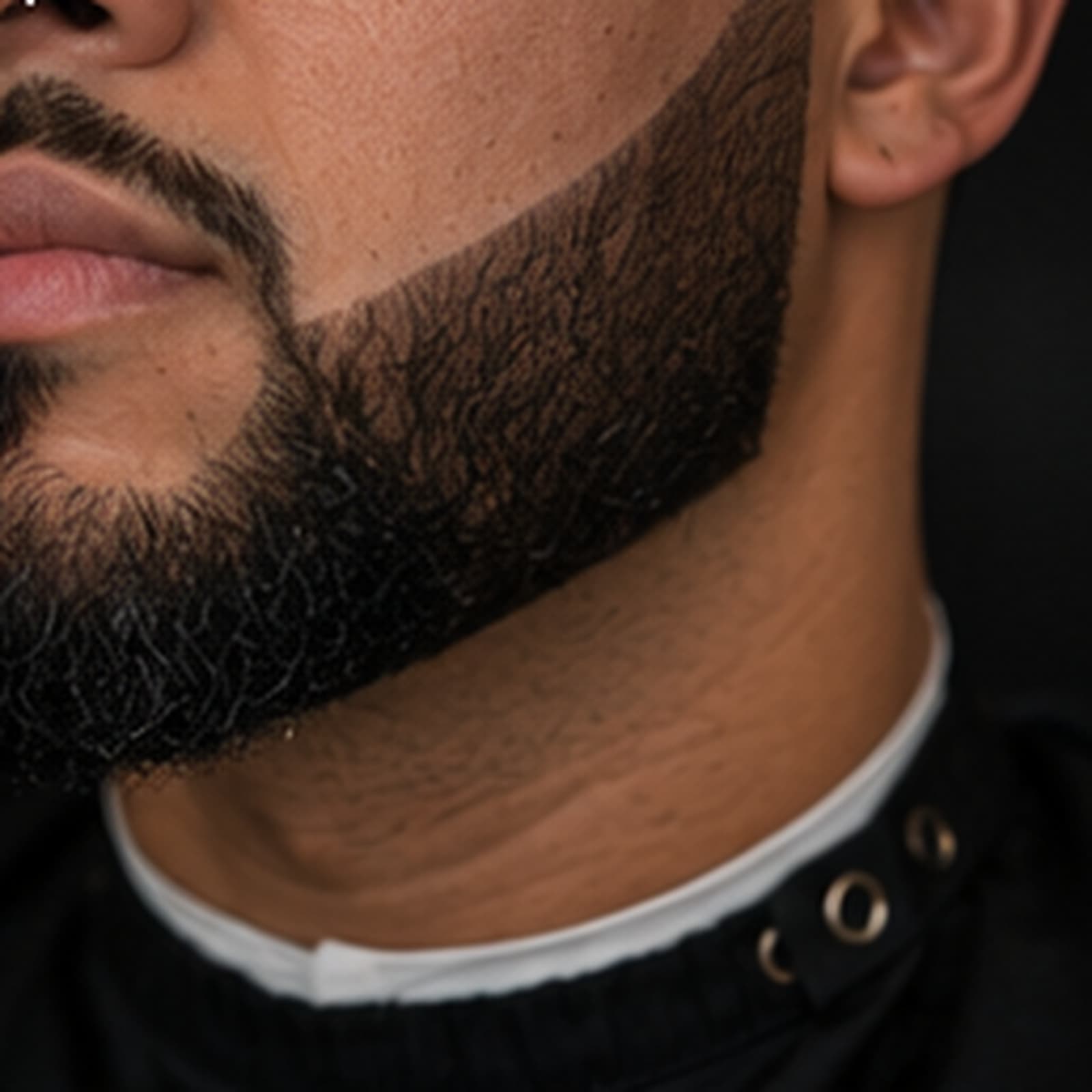 Three-quarter view of a full beard squared to the jaw with a razored cheek line