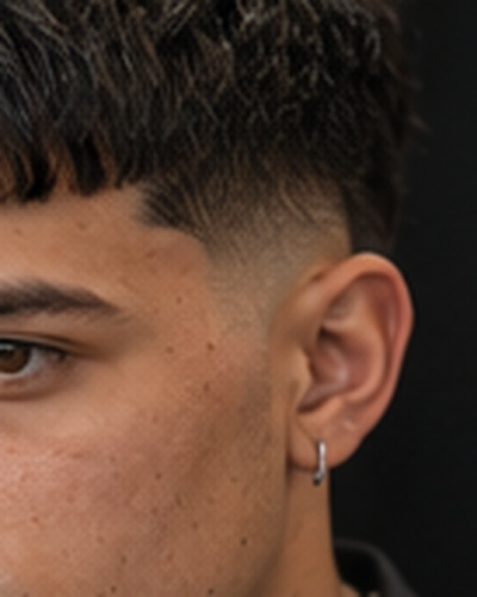 Short textured crop with a blunt fringe over a mid fade